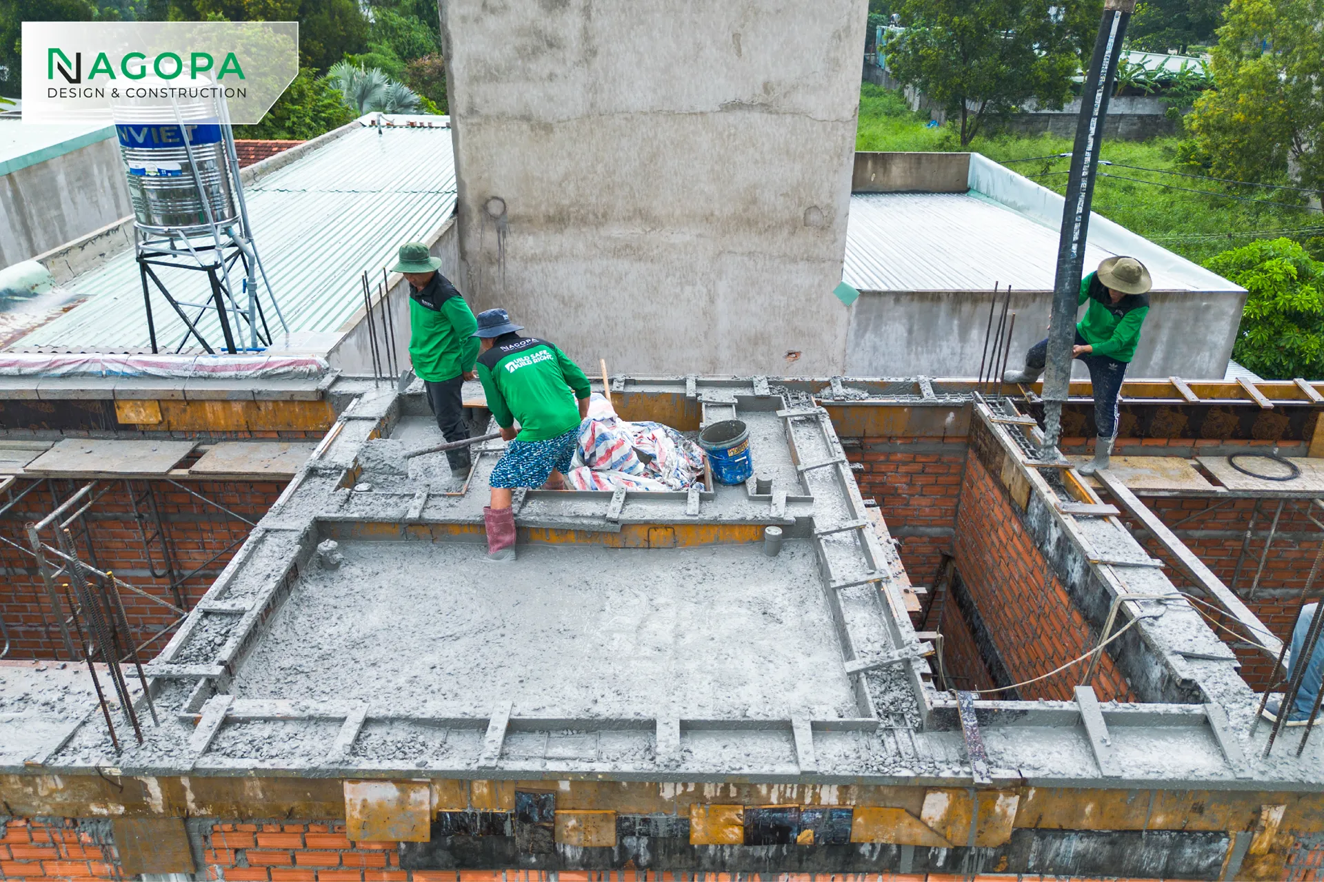 Công nhân công ty NAGOPA đang đầm dùi bê tông tươi trên sàn mái.