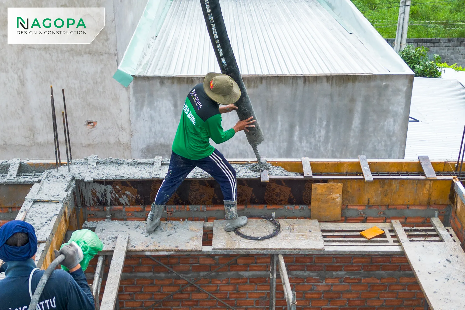 Thợ xây dựng NAGOPA đang thao tác vòi bơm bê tông tươi cho phần dầm sàn mái dự án HHS House tại Chánh Hiệp.